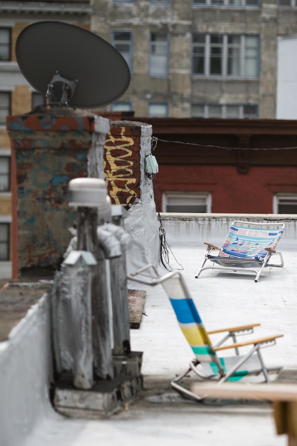 Unused sun loungers on a rooftop. It is a grey day.